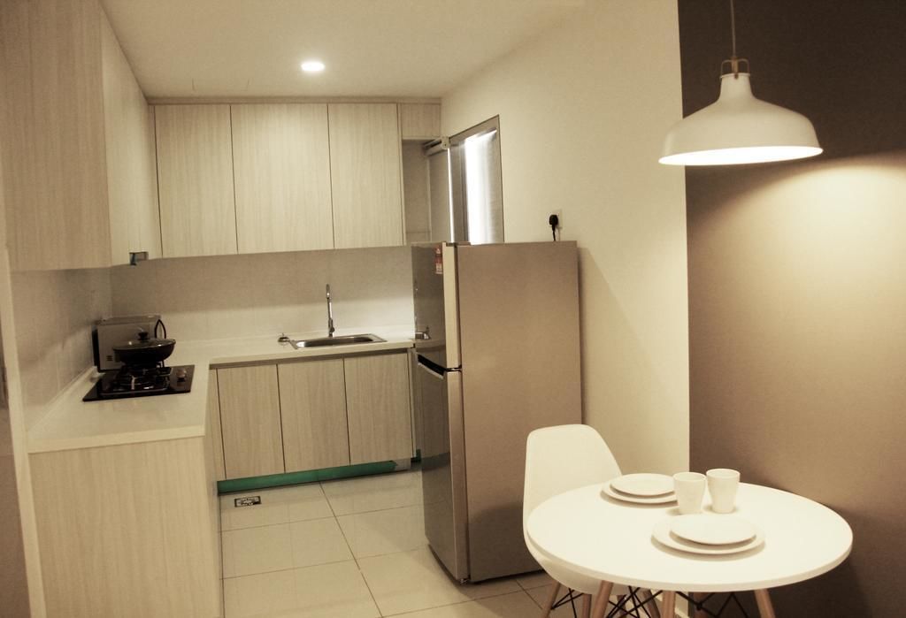 A modern kitchen with light wood cabinets, a stainless steel refrigerator, a sink, and a dining area with a white table and chairs.