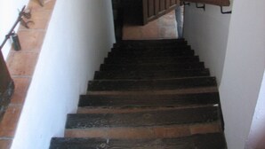 A narrow staircase with wooden steps and a metal handrail. - MORISCA DE LA LUNA HOUSE IN GRANADA. PATIO AND GARDEN. (Granada)