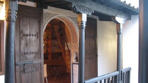 A wooden door with intricate carvings and a metal gate. - MORISCA DE LA LUNA HOUSE IN GRANADA. PATIO AND GARDEN. (Granada)