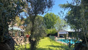 A backyard with a swimming pool, a covered patio, and a lawn. - Family home, swimming pool, 5 bedrooms with private bathrooms Enclosed garden (Saint-Geniès-De-Malgoirès)