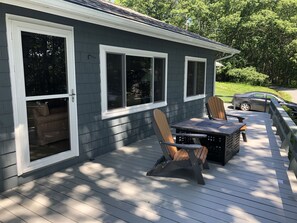 A deck with a table and chairs, a covered seating area, and a car parked nearby.