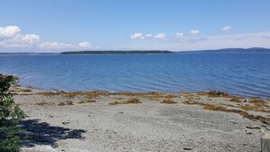 Una costa rocosa con agua tranquila y tierra a lo lejos.
