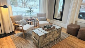 A cozy living room with two armchairs, a coffee table, and a rustic chest of drawers. - Charming East side-Marquette Home Convenient to Beach, Nmu & Hospital (Marquette)