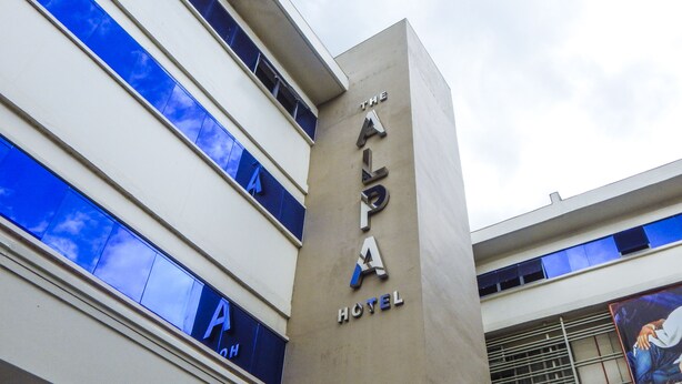 Un letrero de hotel con el nombre "The Alpa Hotel".
