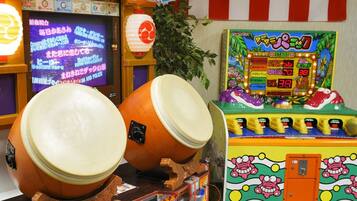 Experience the vibrant arcade atmosphere, featuring a traditional Japanese drum set and classic games like Namco Pac-Man.