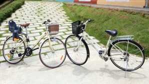 A pathway leading to a row of colorful houses with bicycles parked in front. - The Box House (Krabi)