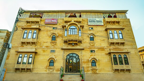 A historic building with ornate architecture, featuring multiple balconies and a central entrance with a staircase. - Hotel Marina Mahal (Jaisalmer)