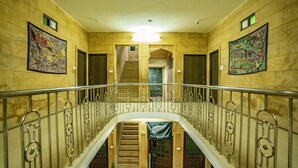 A grand staircase with ornate metal railings and a banner reading "All Blacks". - Hotel Marina Mahal (Jaisalmer)