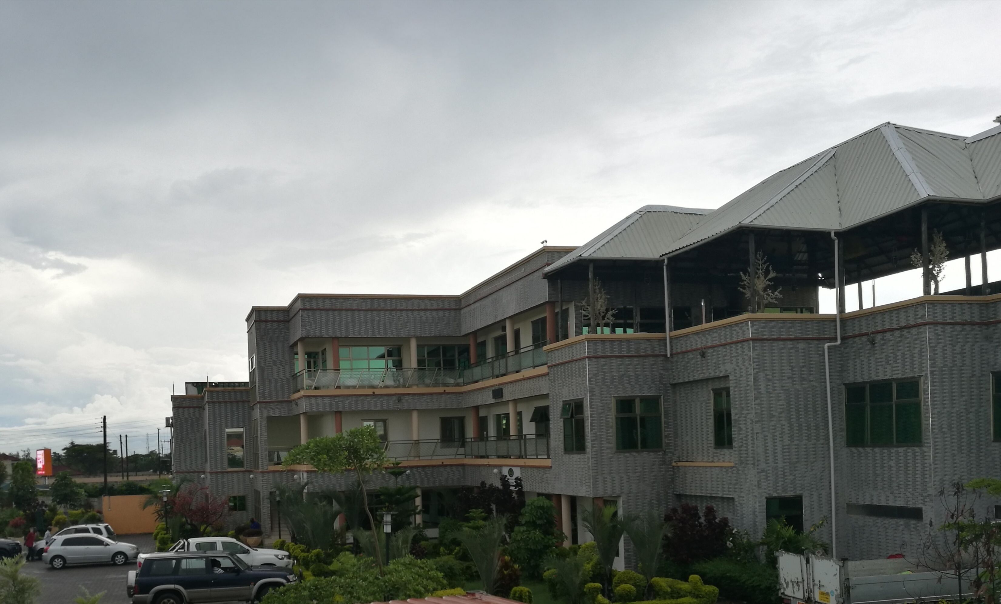 A multi-story building with a modern architectural design, featuring balconies and large windows.