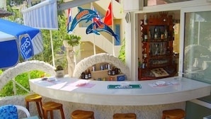 Eine Bar mit Theke, Hockstühlen und einer mit Flaschen bestückten Bar.