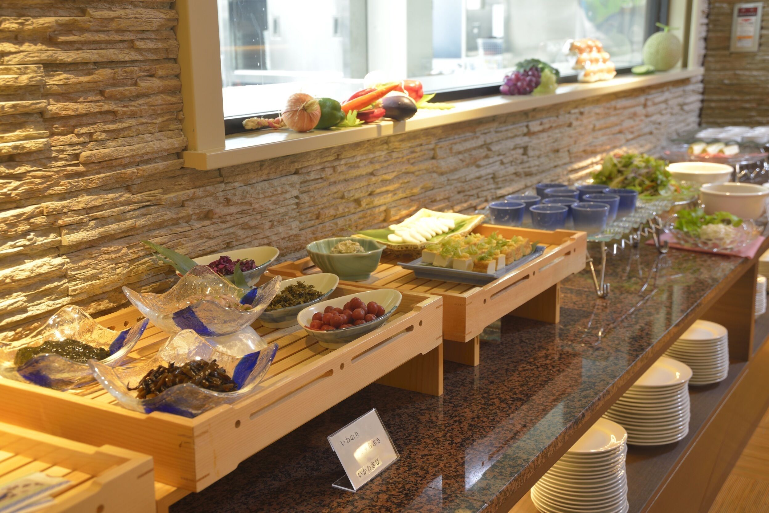 Ein reichhaltiges Buffet mit verschiedenen Speisen und einer Wand aus Stein im Hintergrund.