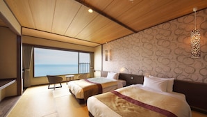 Habitación de hotel con dos camas, un ventanal con vistas al mar, techo de madera y pared con diseño.