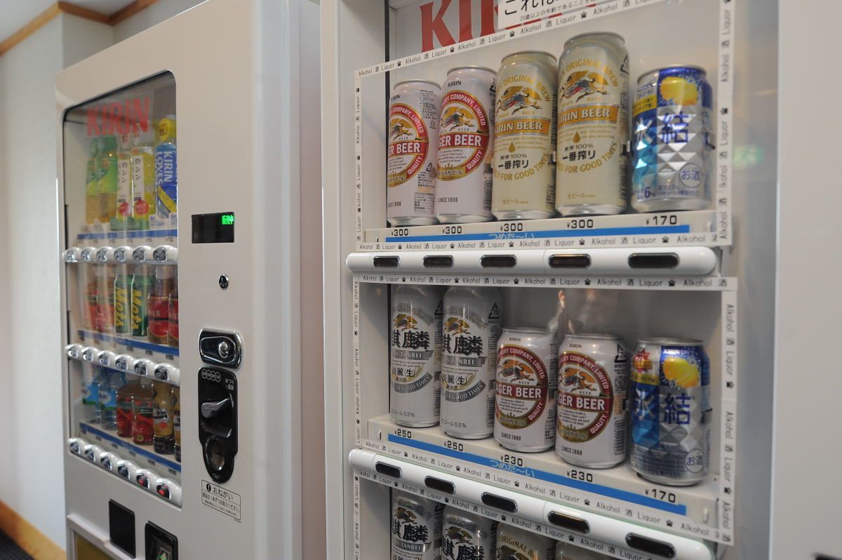 Un distributeur automatique contenant différentes sortes de bières en conserve et d’autres boissons.