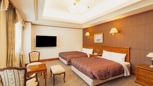 A hotel room with two beds, a desk, a chair, a television, and a ceiling light. - Hotel Racine Sinmaebashi (Maebashi)
