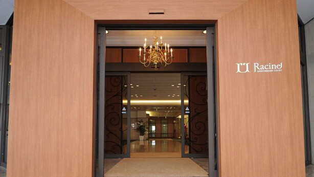 The entrance to Racine's Anniversary Court with a modern design, featuring a chandelier and a clear view into the interior. - Hotel Racine Sinmaebashi (Maebashi)
