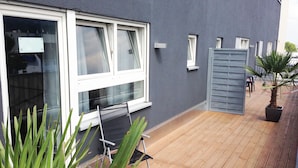 A wooden deck with a folding chair and a potted plant. - Boardinghotel Heidelberg (Heidelberg)