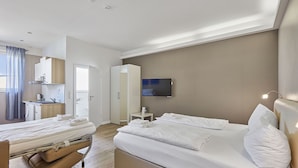 A modern hotel room with a bed, bedside table, and a small desk area. - Boardinghotel Heidelberg (Heidelberg)