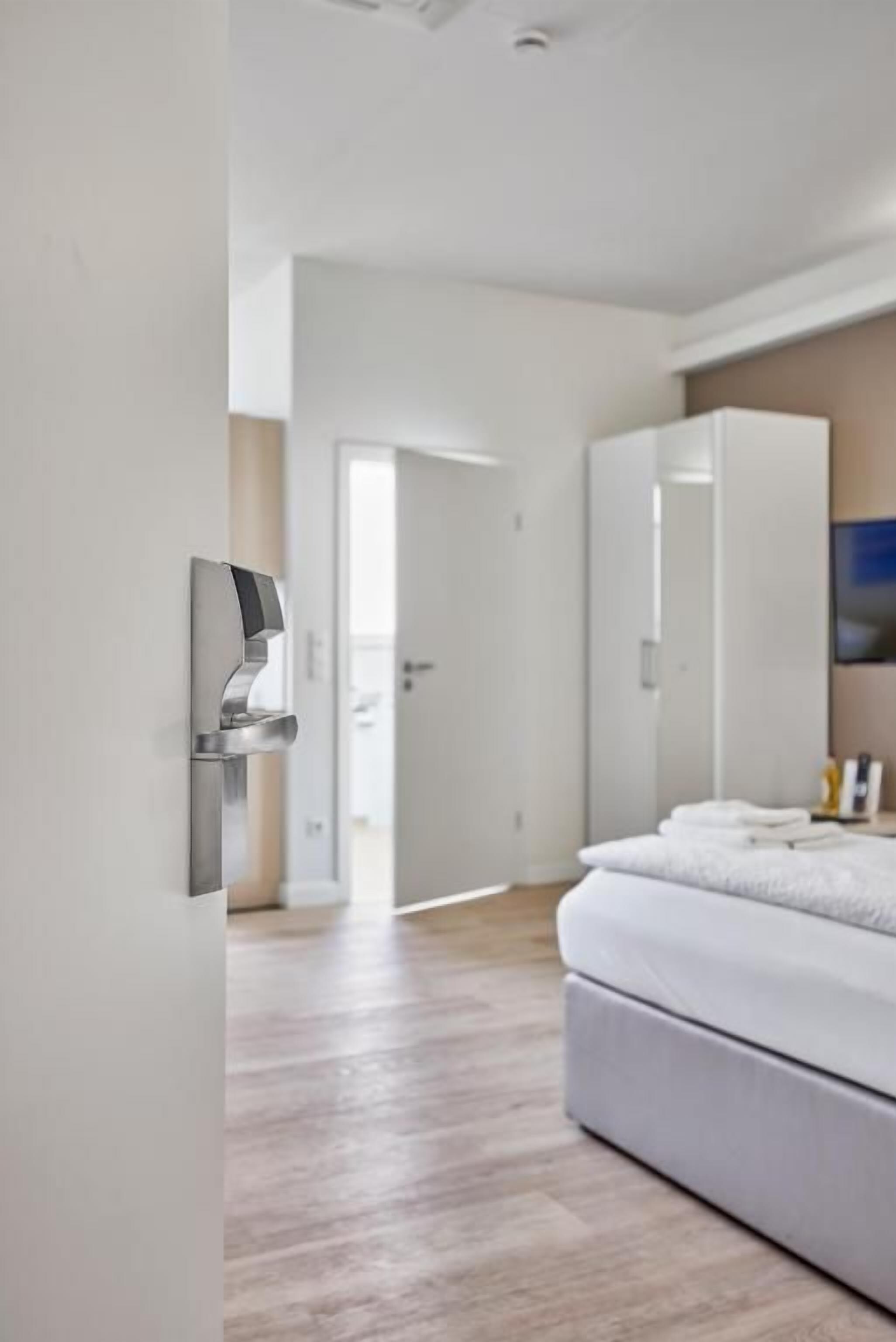 Un dormitorio moderno con cama, armario y puerta que da a otra habitación.
