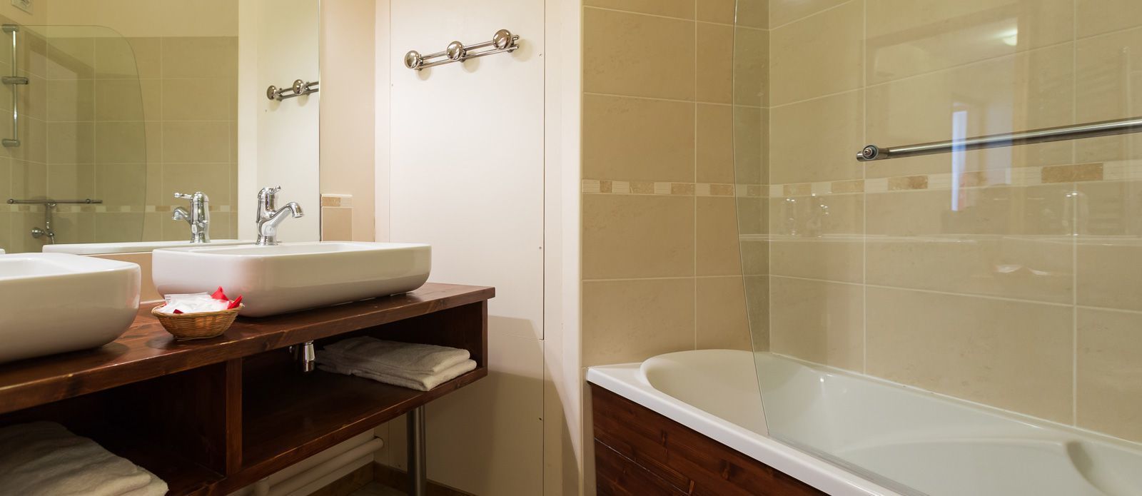 Un bagno con due lavandini, una vasca e un box doccia in vetro.