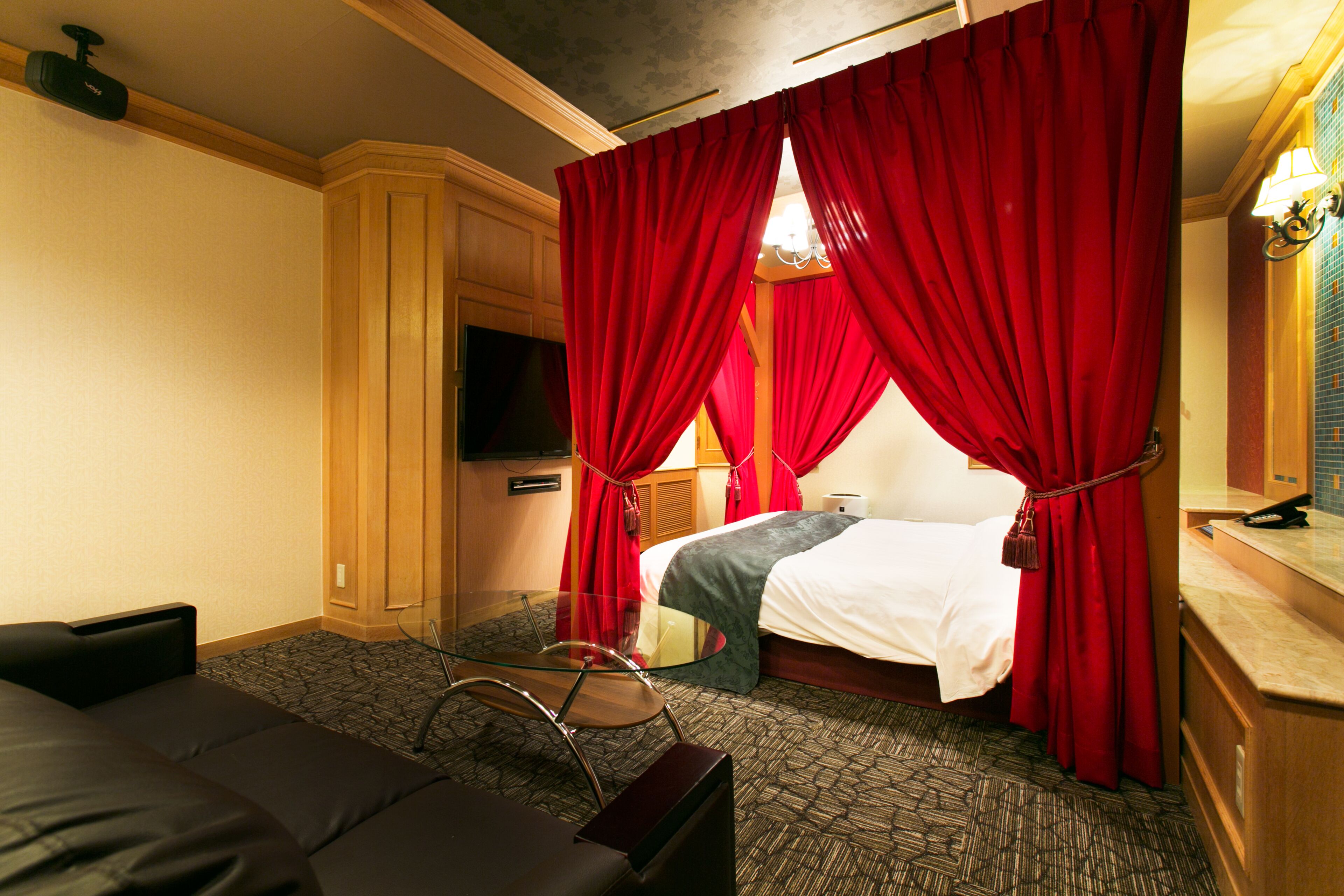 A hotel room with a bed, a TV, a desk, and a chair.