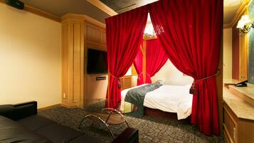 Una habitación de hotel con cama, televisión, escritorio y silla.