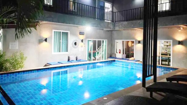 A two-story building with a swimming pool, balconies, and a staircase leading to the upper floor. - Villa Rajapruek Entire 3 villas 7 bedrooms near airport (Chiang Mai)