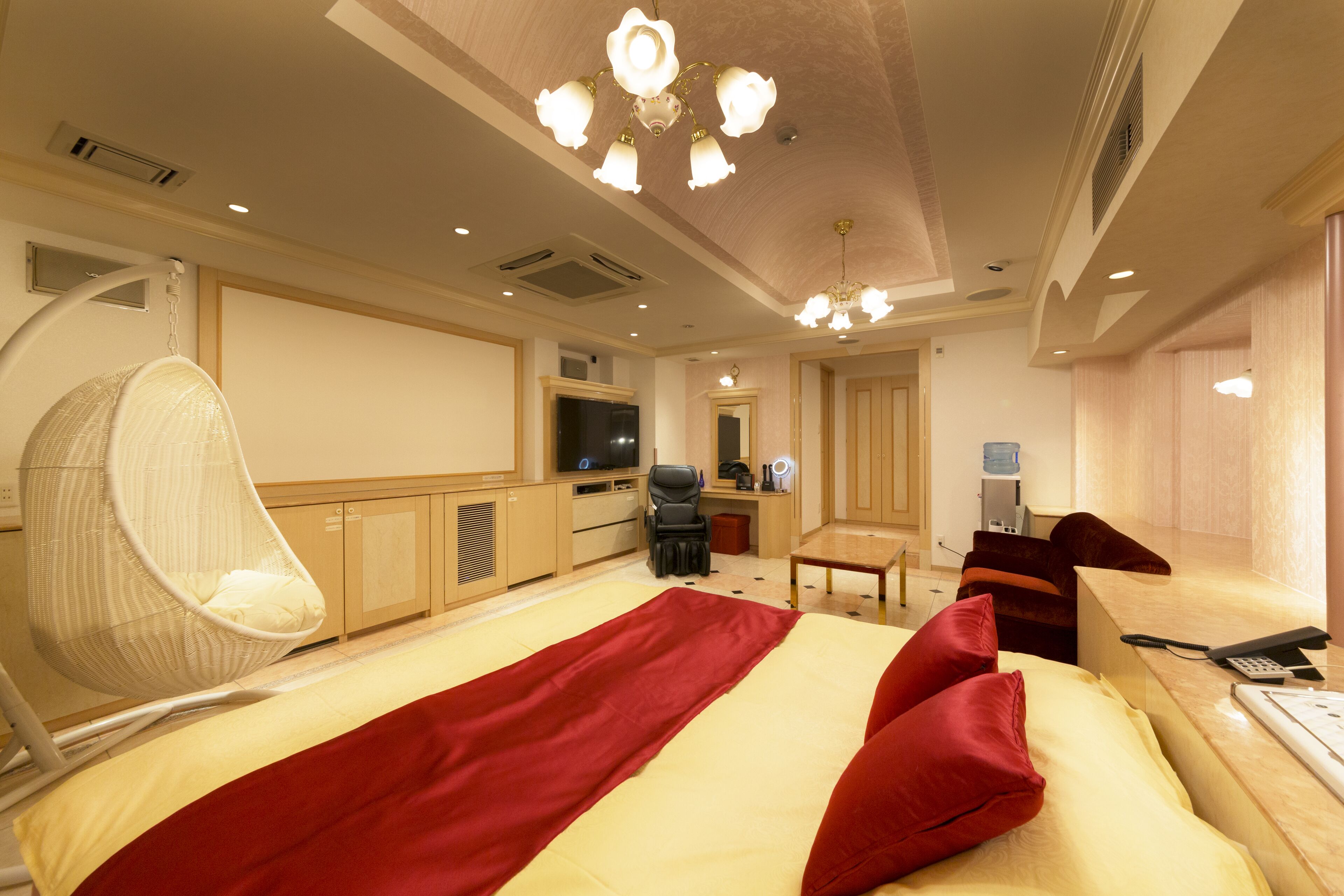 A hotel room with a bed, a chair, a desk, a television, and a bathroom.