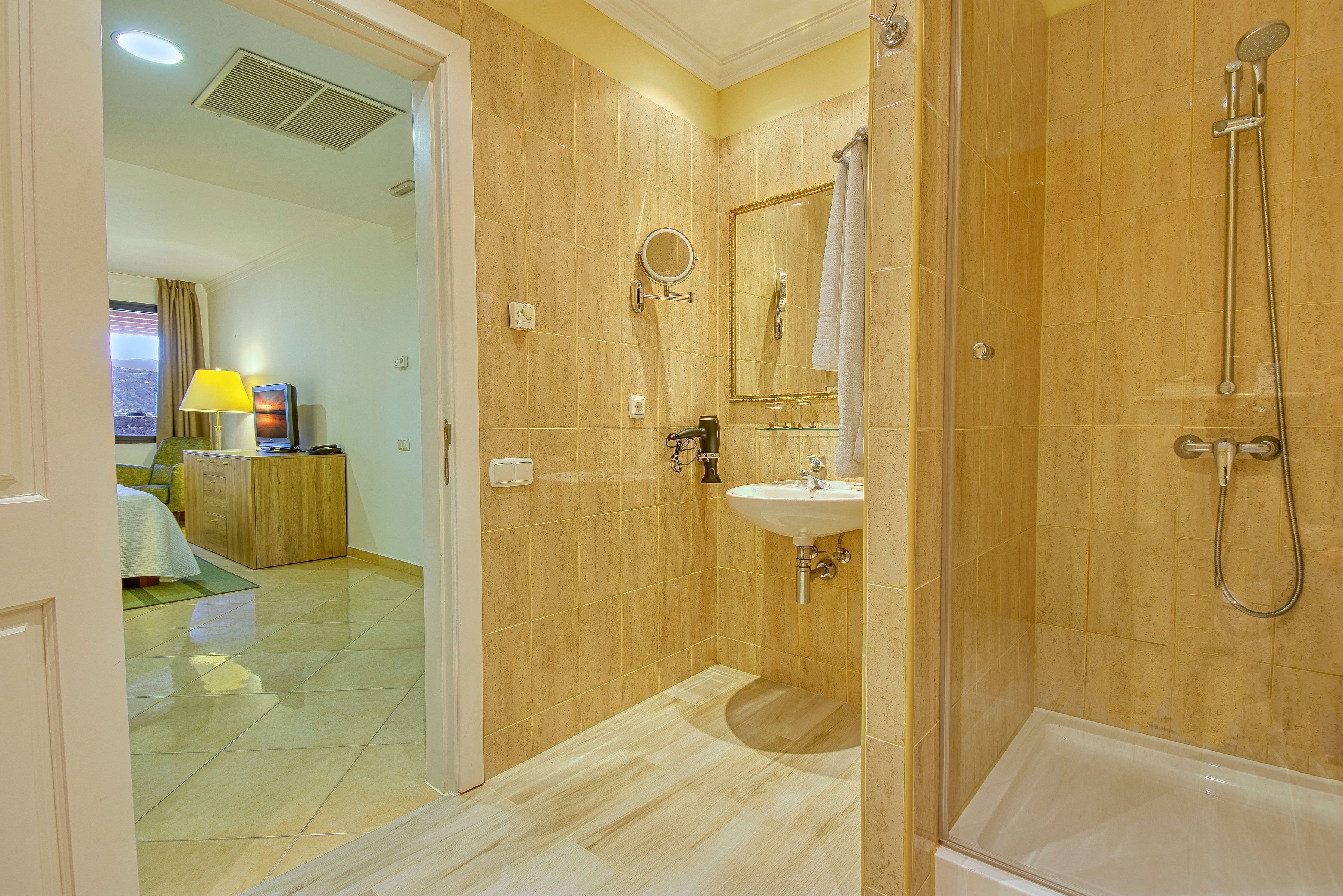 Ein Badezimmer mit Dusche, Waschbecken und Spiegel.