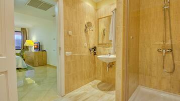 Ein Badezimmer mit Dusche, Waschbecken und Spiegel.