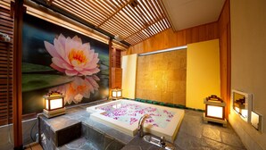 A spa room with a large bathtub, wooden slats, a lotus flower mural, and stone flooring. - Hotel Lotus Nara - Adults Only (Nara)