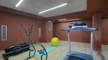 A gym with exercise equipment including treadmills, a stationary bike, and a trampoline.