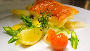 Een bord met zalm, asperges, citroen en kerstomaatjes.