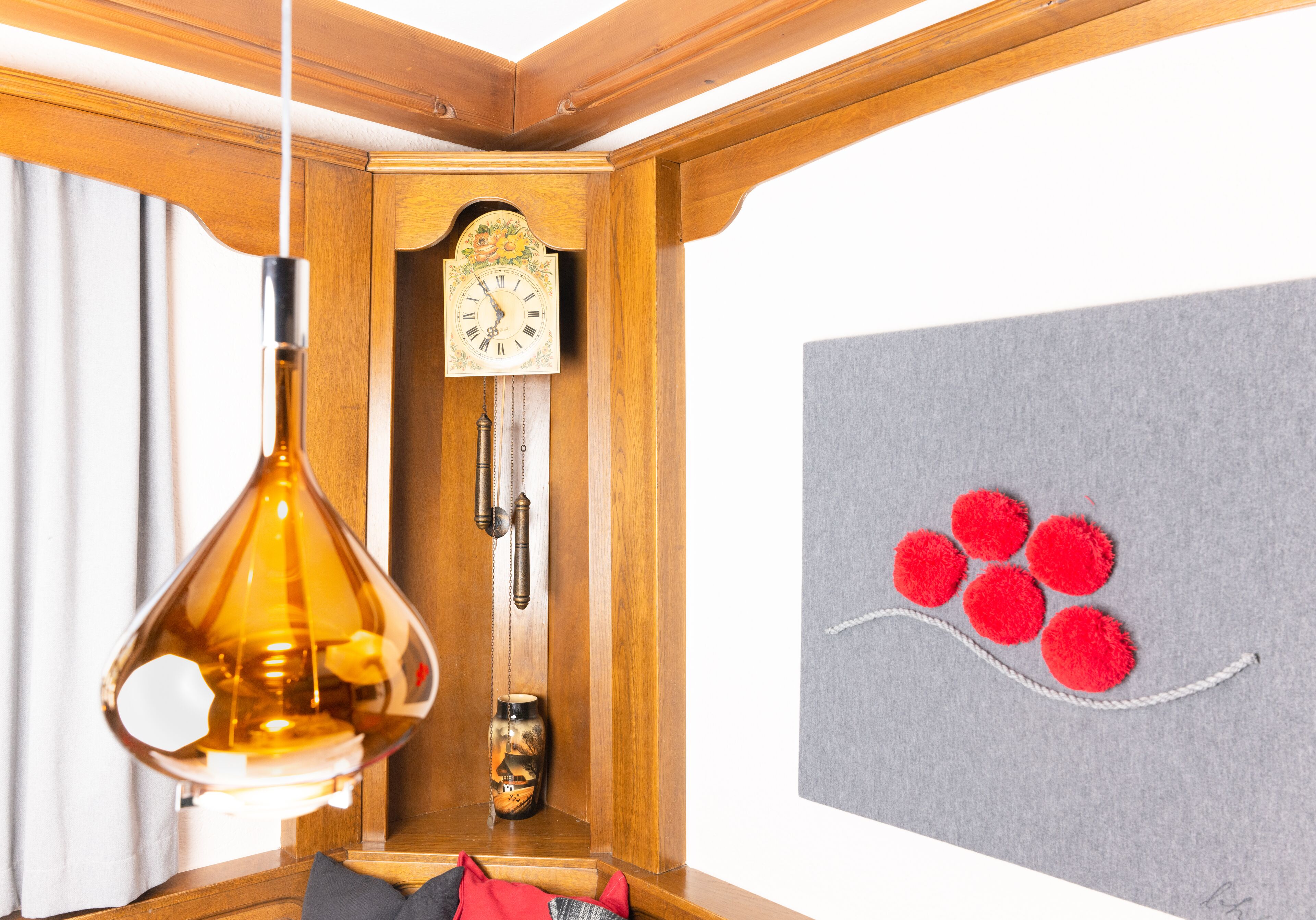 A wooden wall with a clock and a hanging light fixture.