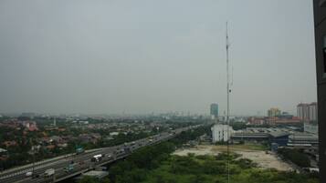 A cityscape with a highway, buildings, and a tall communication tower.