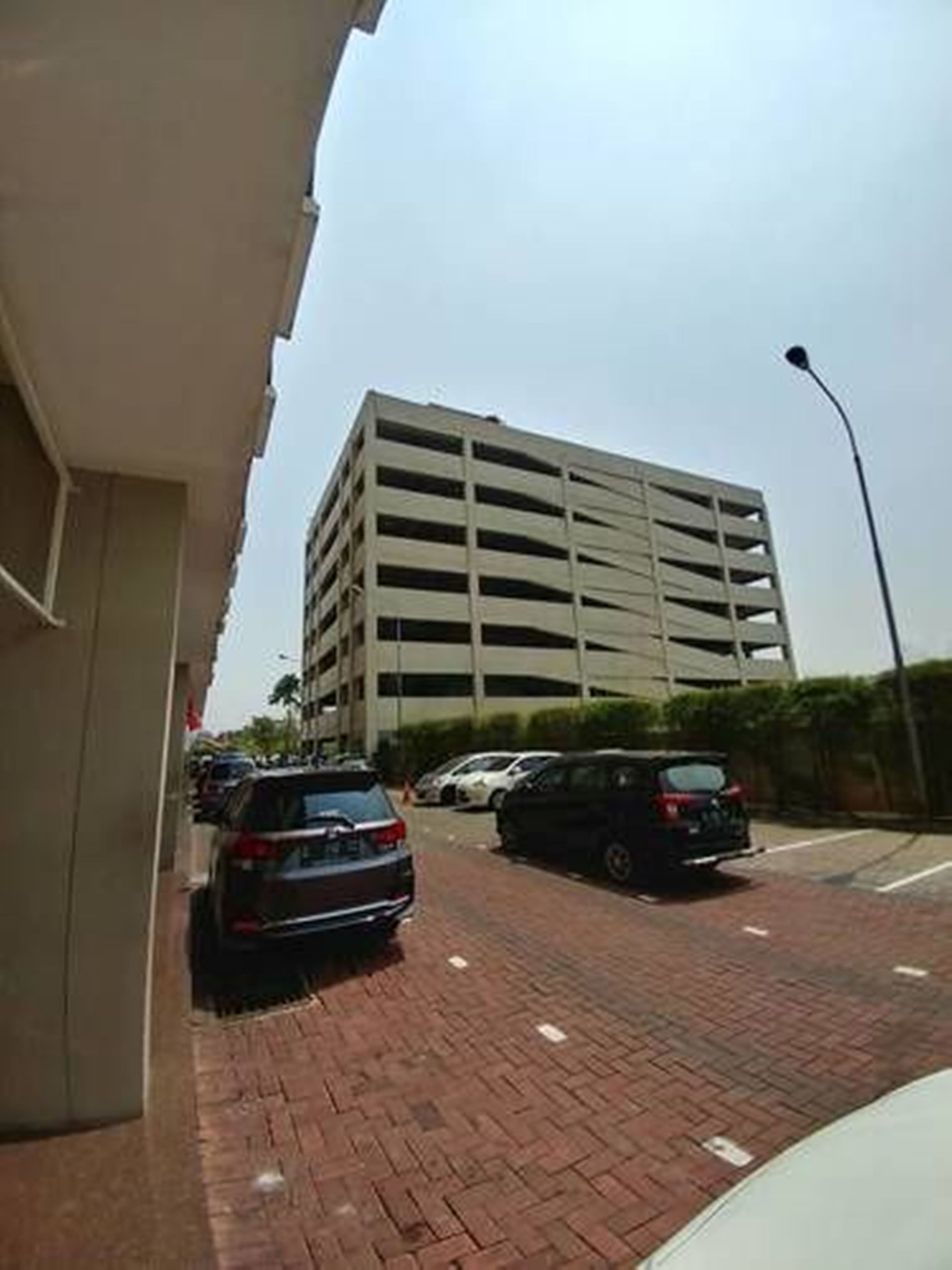 Un aparcamiento de varios pisos con varios coches estacionados en la planta baja.