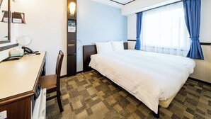 A hotel room with a bed, a desk with a telephone, a chair, a mirror, and a window with curtains. - Toyoko Inn Kintetsu Yokkaichi-eki Kita-guchi (Yokkaichi)