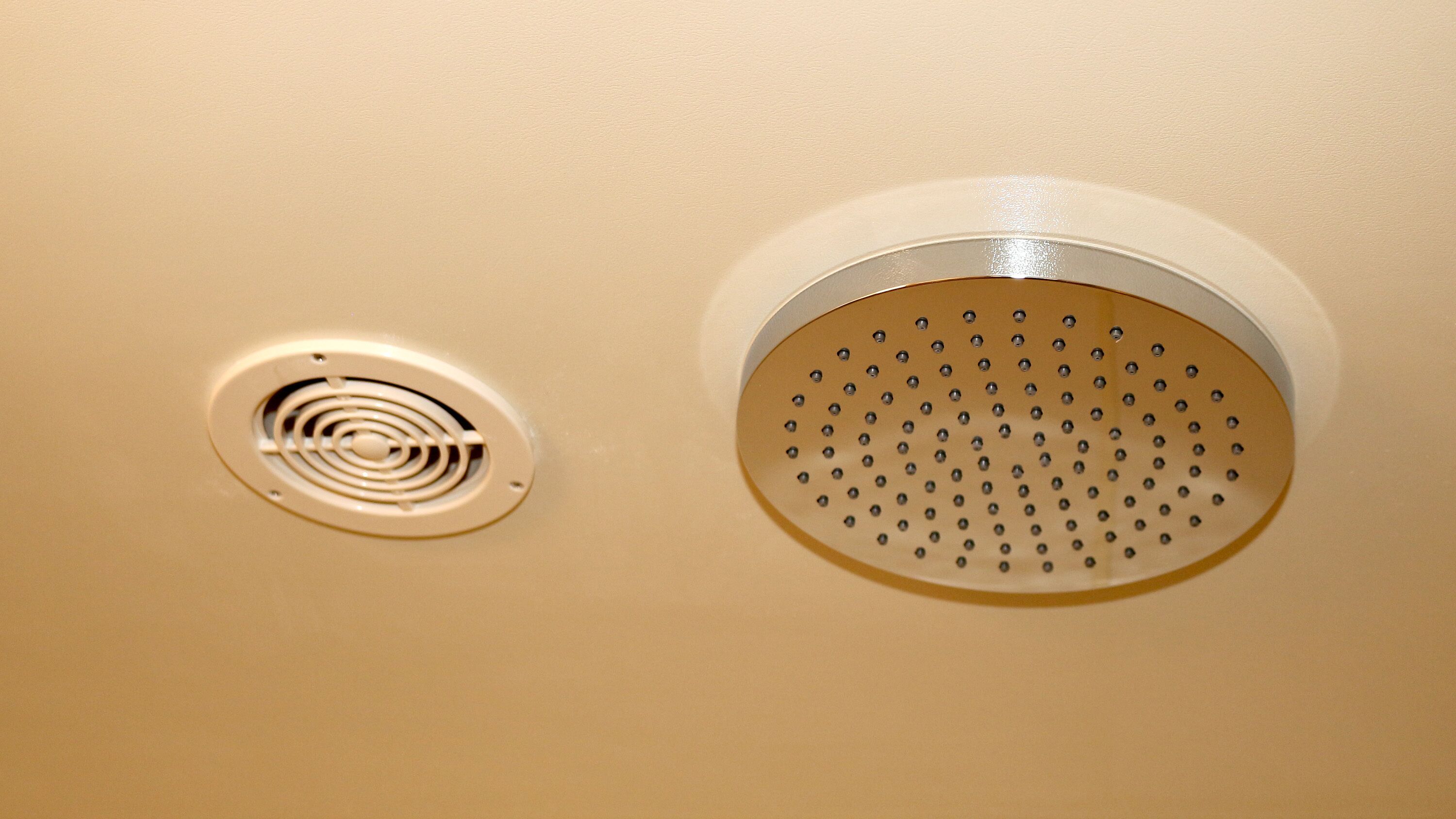 A ceiling with two ventilation grilles, one circular and one spiral.