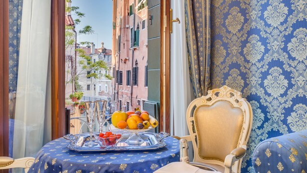 A balcony with a table set for dining, featuring a fruit bowl and glassware. - Residenza Veneziana (Venice)