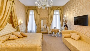 A luxurious room with a large bed, a sofa, a chandelier, and a mirror. - Residenza Veneziana (Venice)