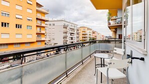 A balcony with a glass railing, white chairs, and a small table. - B&B Casa Der Poeta (Rome)