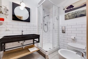 A modern bathroom with a black vanity, white tiles, a glass-enclosed shower, and a white toilet. - B&B Casa Der Poeta (Rome)