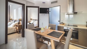 Una habitación de hotel moderna con comedor, cocina y dormitorio.