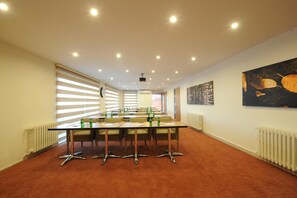 A conference room with a long table, chairs, and a projector. - Kardes Hotel (Bursa)