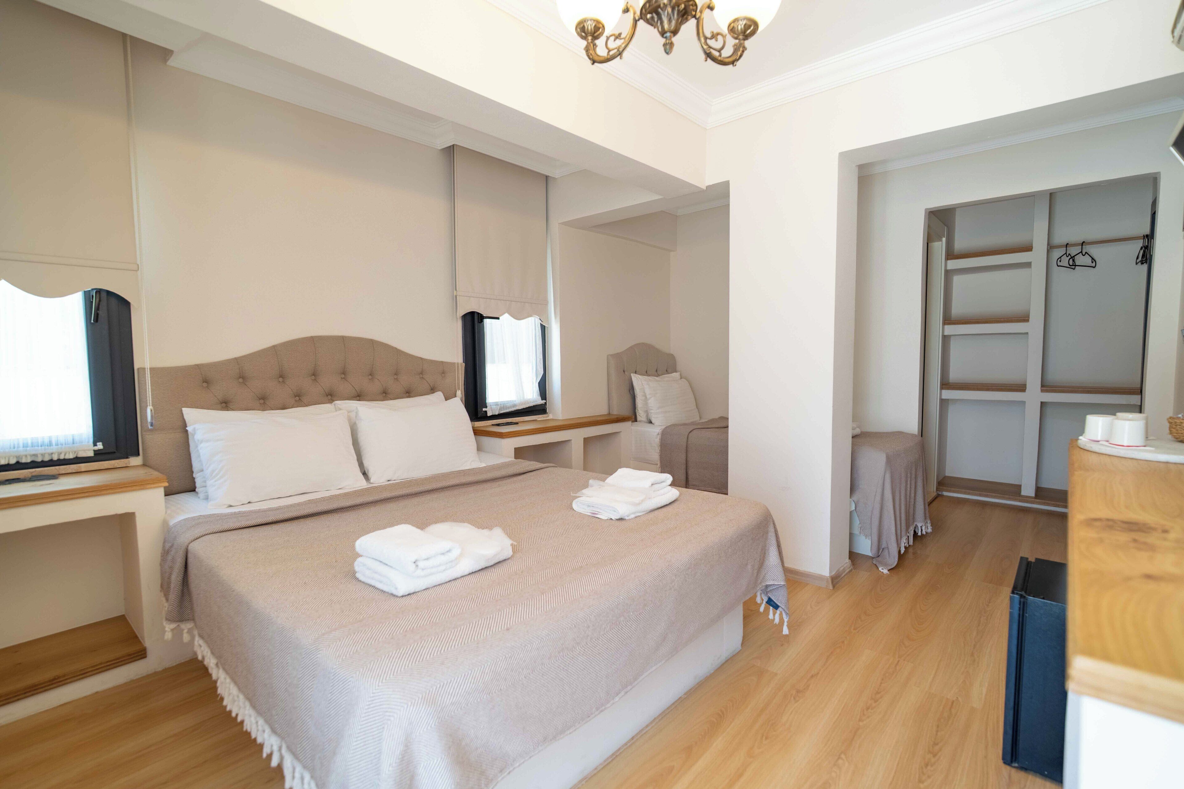 Habitación de hotel con una cama grande, televisión, escritorio y armario.
