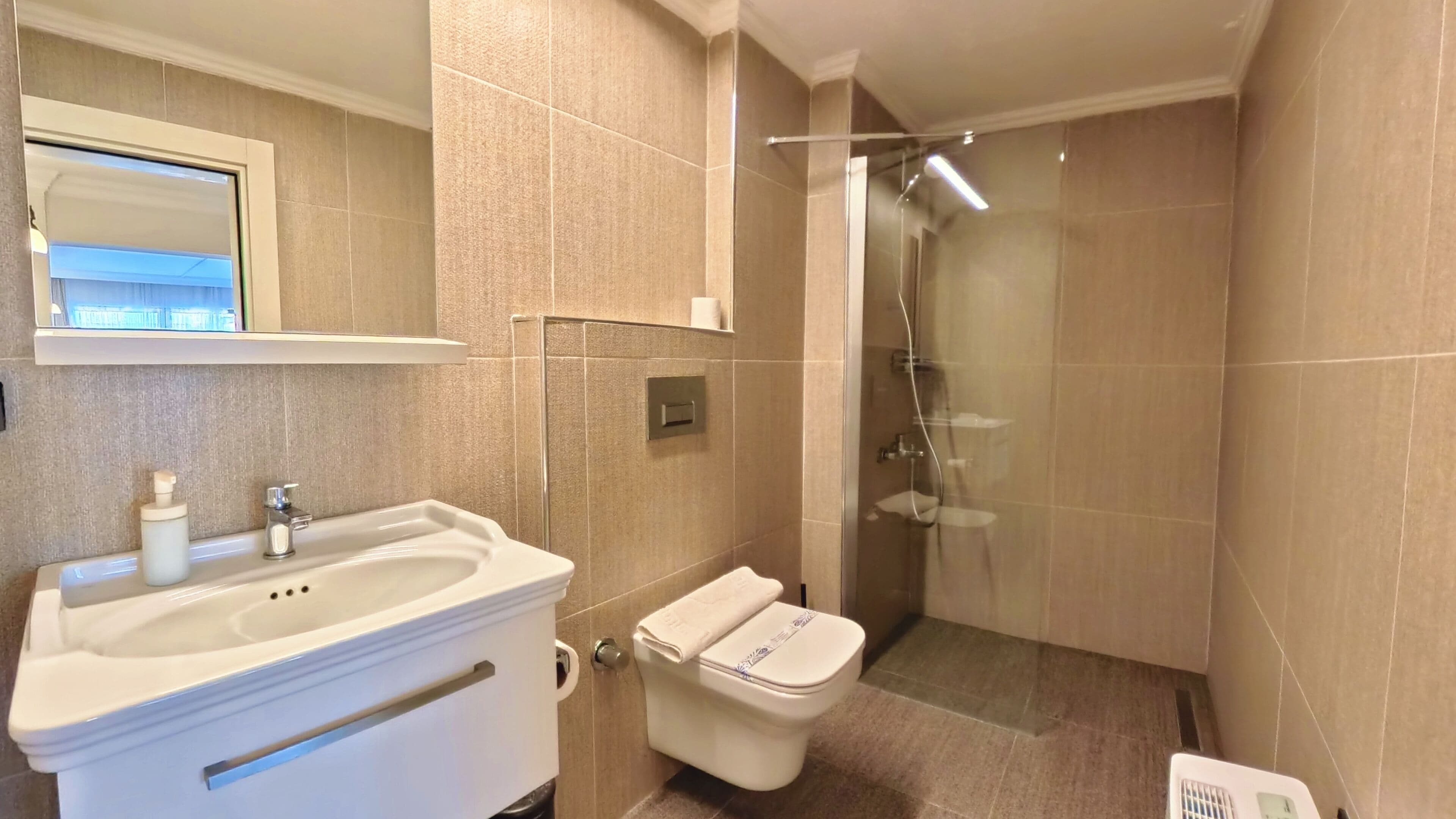 A bathroom with a sink, toilet, and shower.