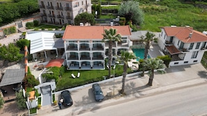 Un hotel de varios pisos con piscina, zona de estar al aire libre y aparcamiento.