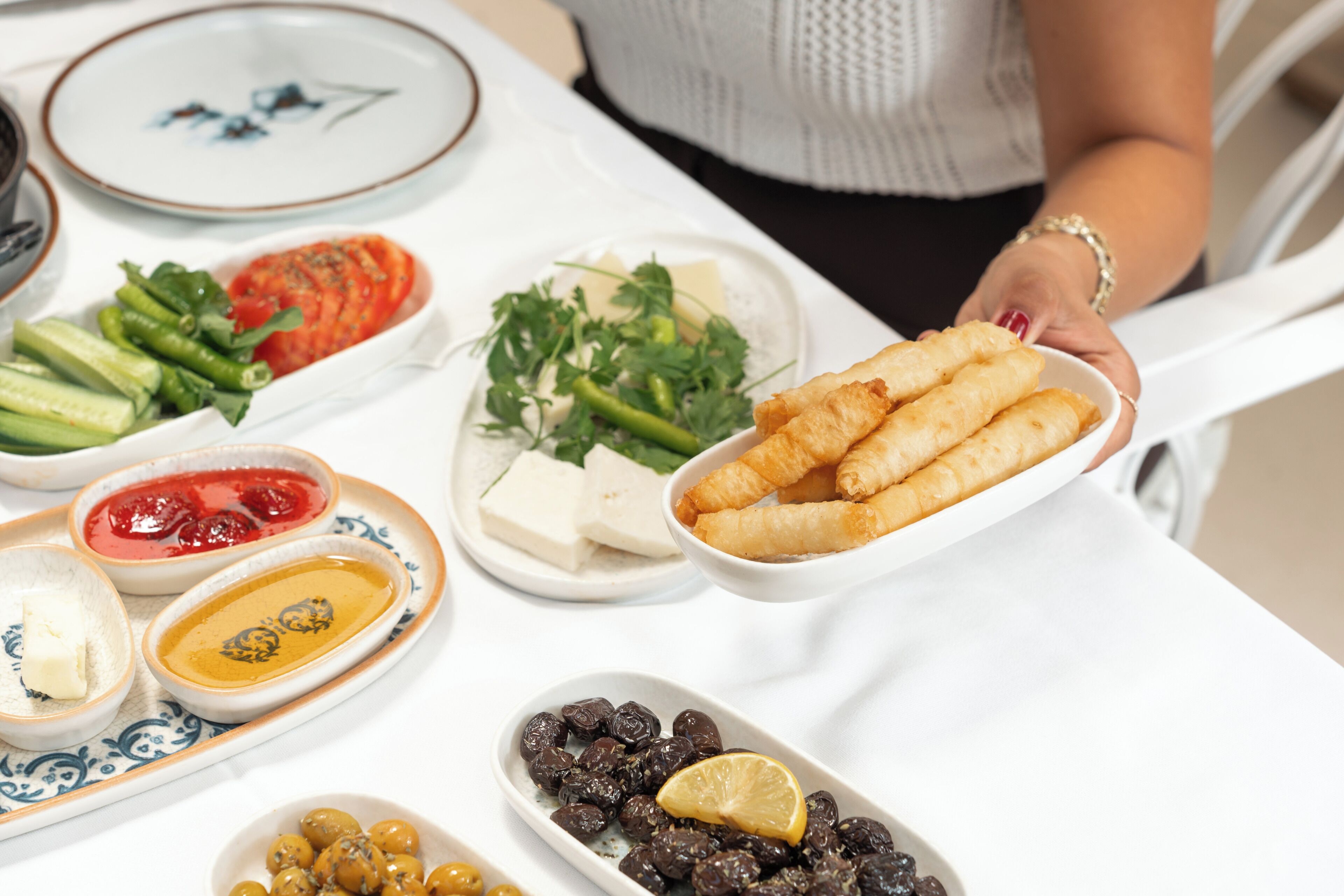A table with various food items including breadsticks, cheese, and olives.