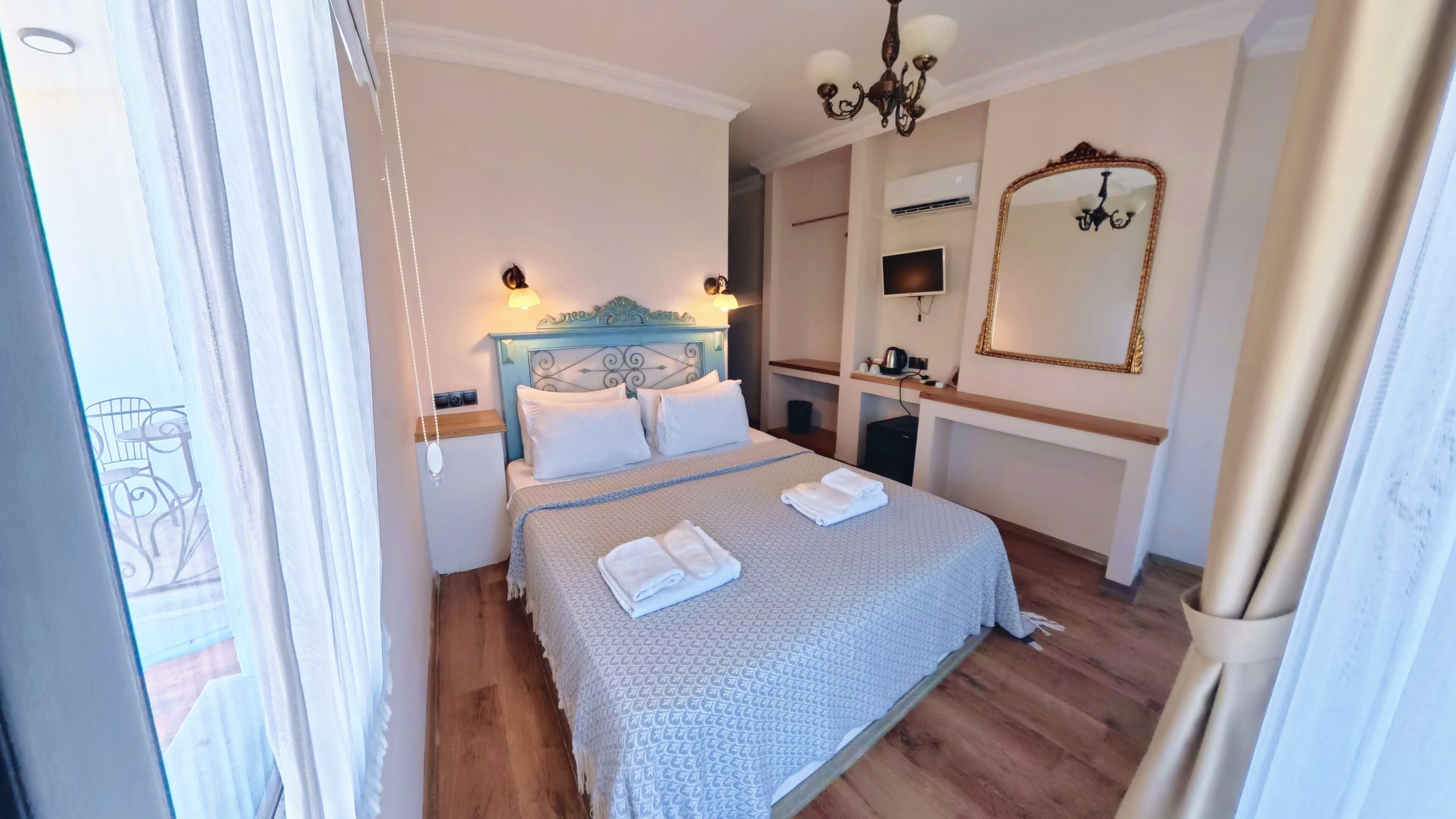 Une chambre d’hôtel avec un lit, une table de chevet, une lampe et un miroir.