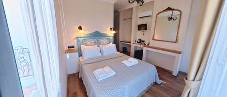 Une chambre d’hôtel avec un lit, une table de chevet, une lampe et un miroir.