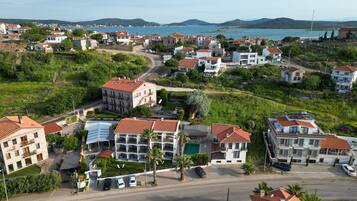 Un área residencial costera con varias casas de dos pisos, una piscina y vista al mar.